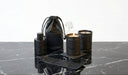Set of black candles and containers on a marble surface